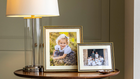 Two Marble Bead Mounted Photo Frames with a wedding photo and lifestyle shot of a young girl in a field on an antiqiue side table